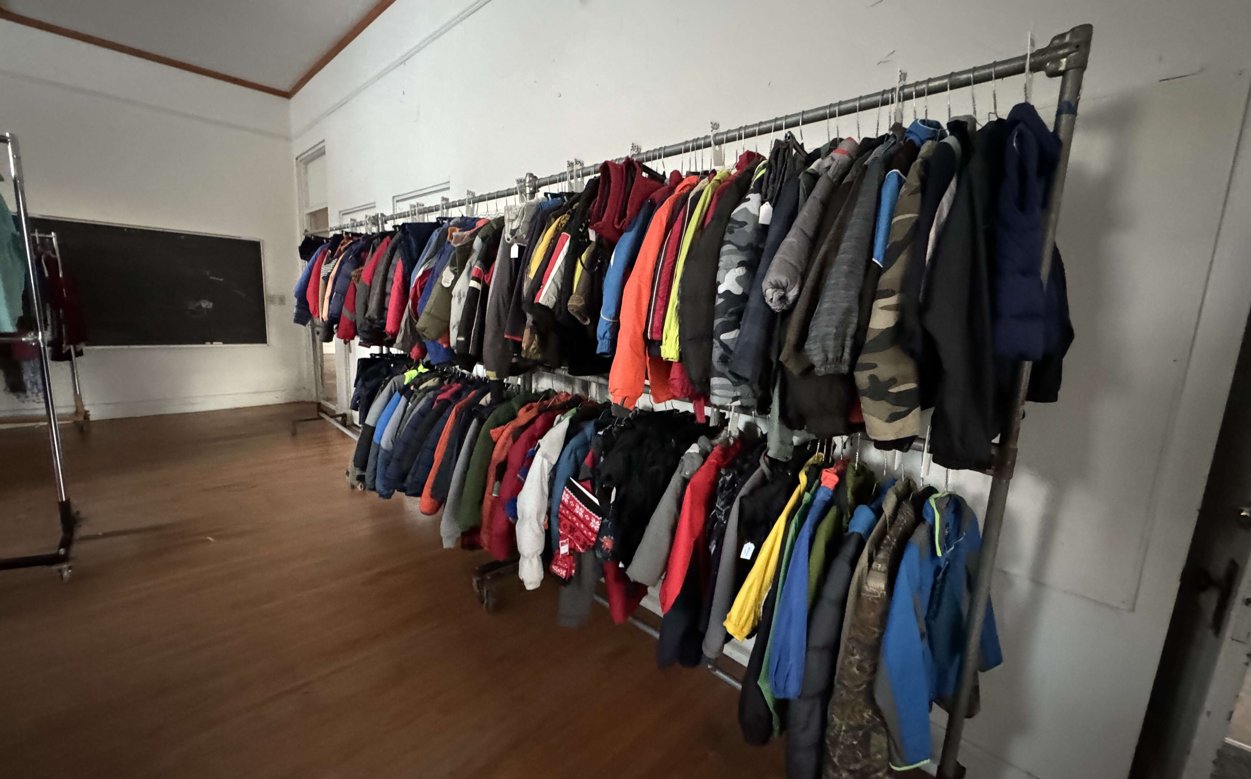 A double rack is loaded wtih clothes.