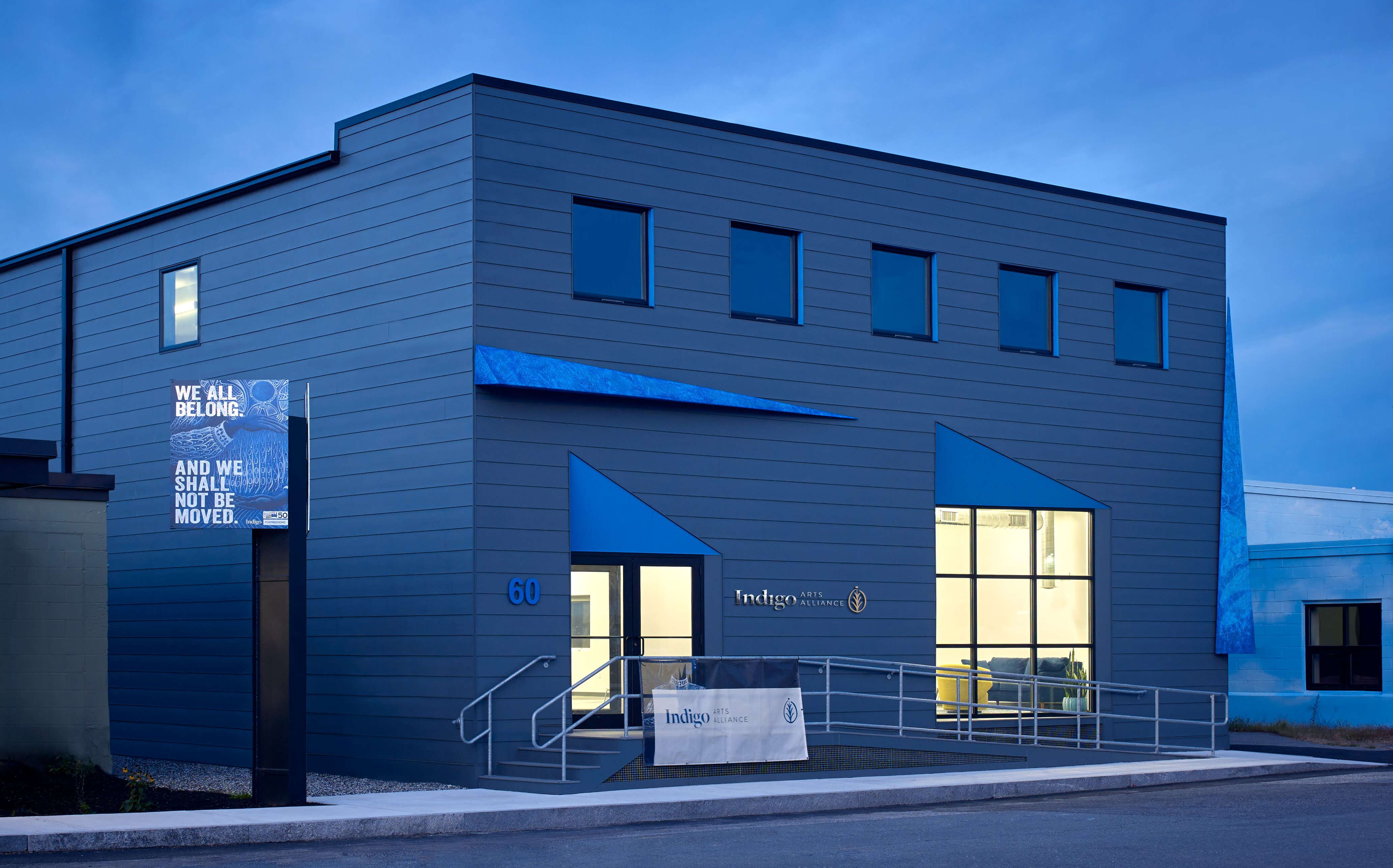 A blue-tinted photo shows the exterior of a square building.