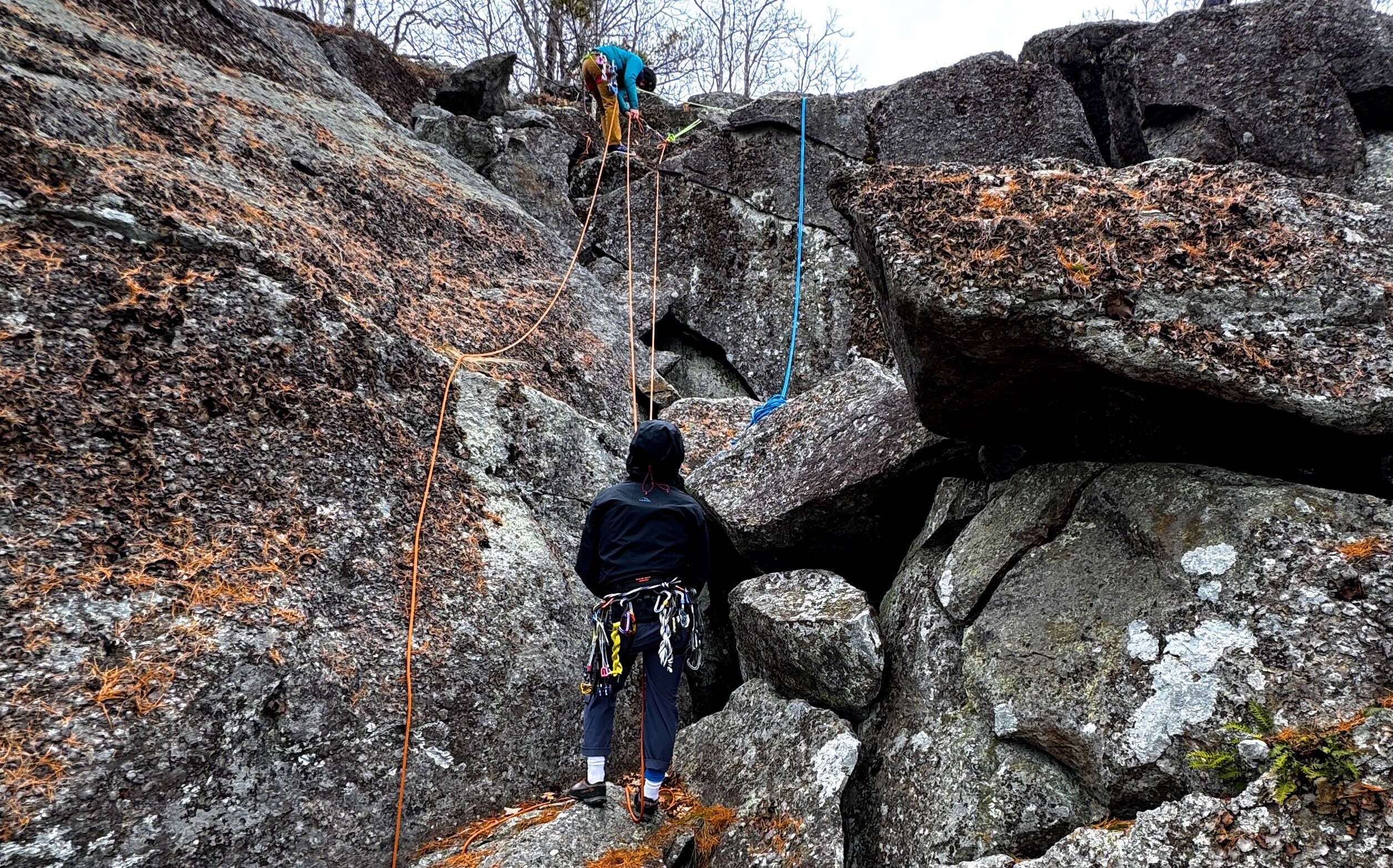 Two people climb rocks.