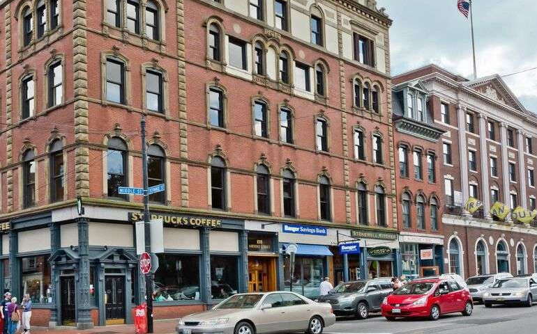 A city street has buildings and cars.