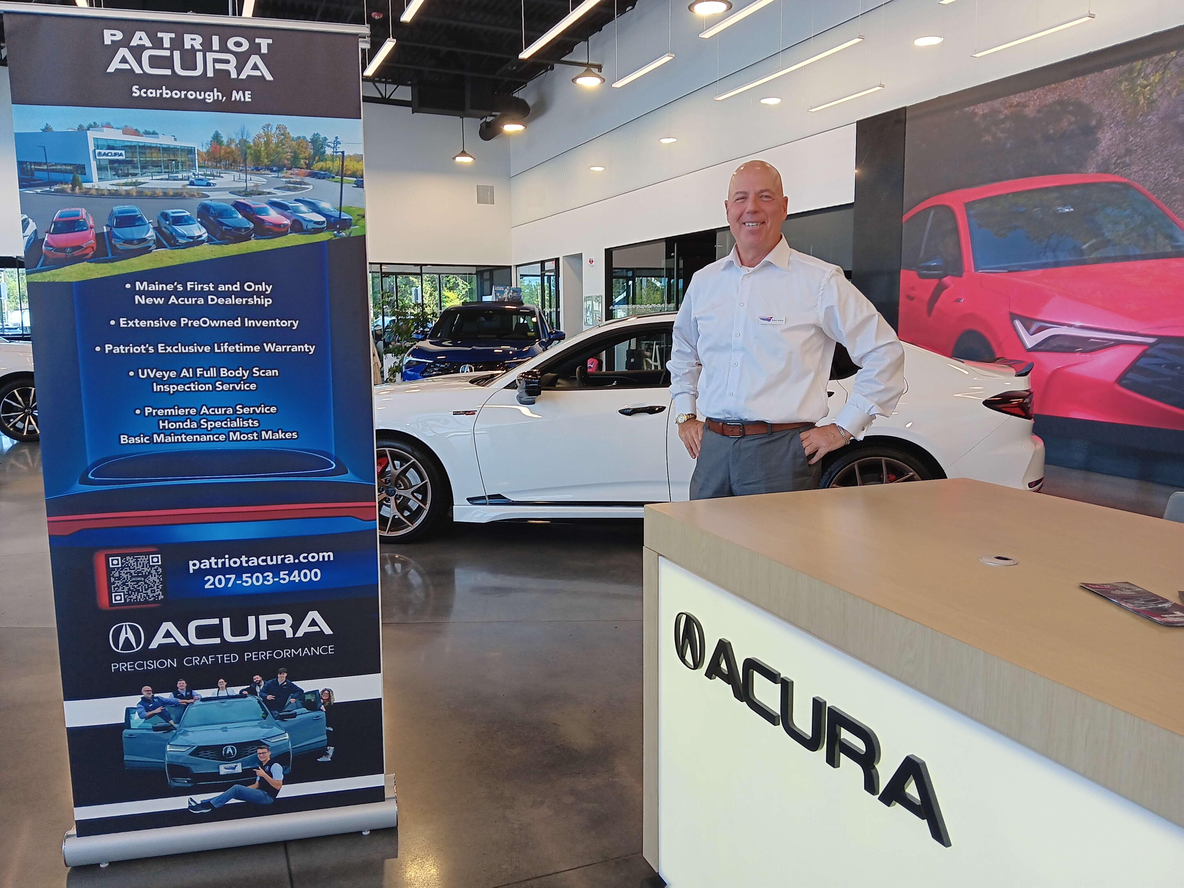 man stands in Acura dealership showroom