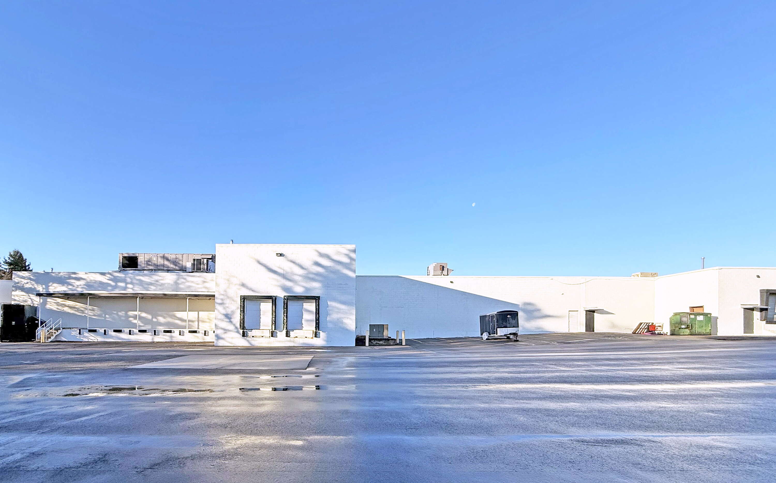 An exterior view of a long, low white building.