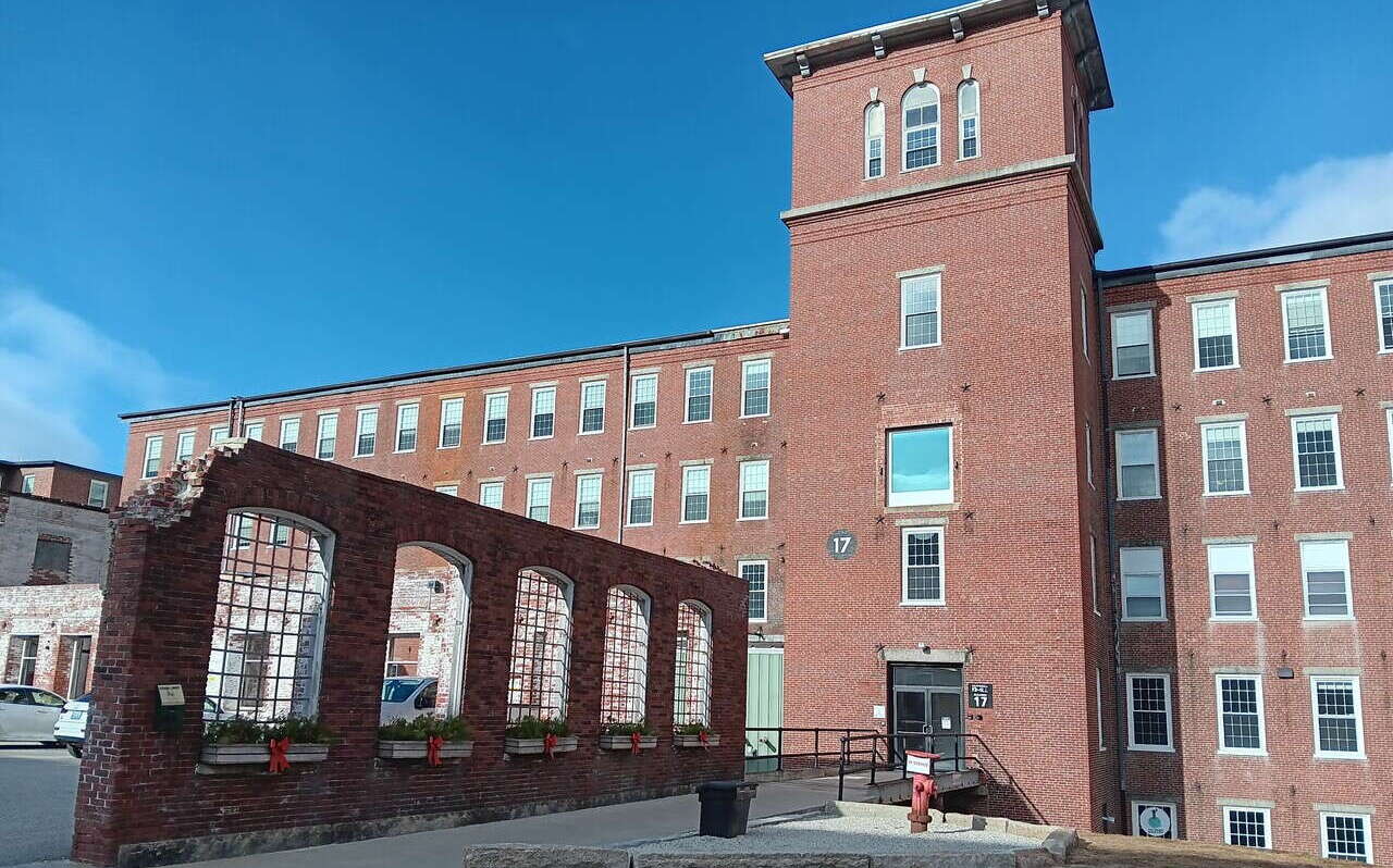 A brick building has brick and concrete structures in front of it.