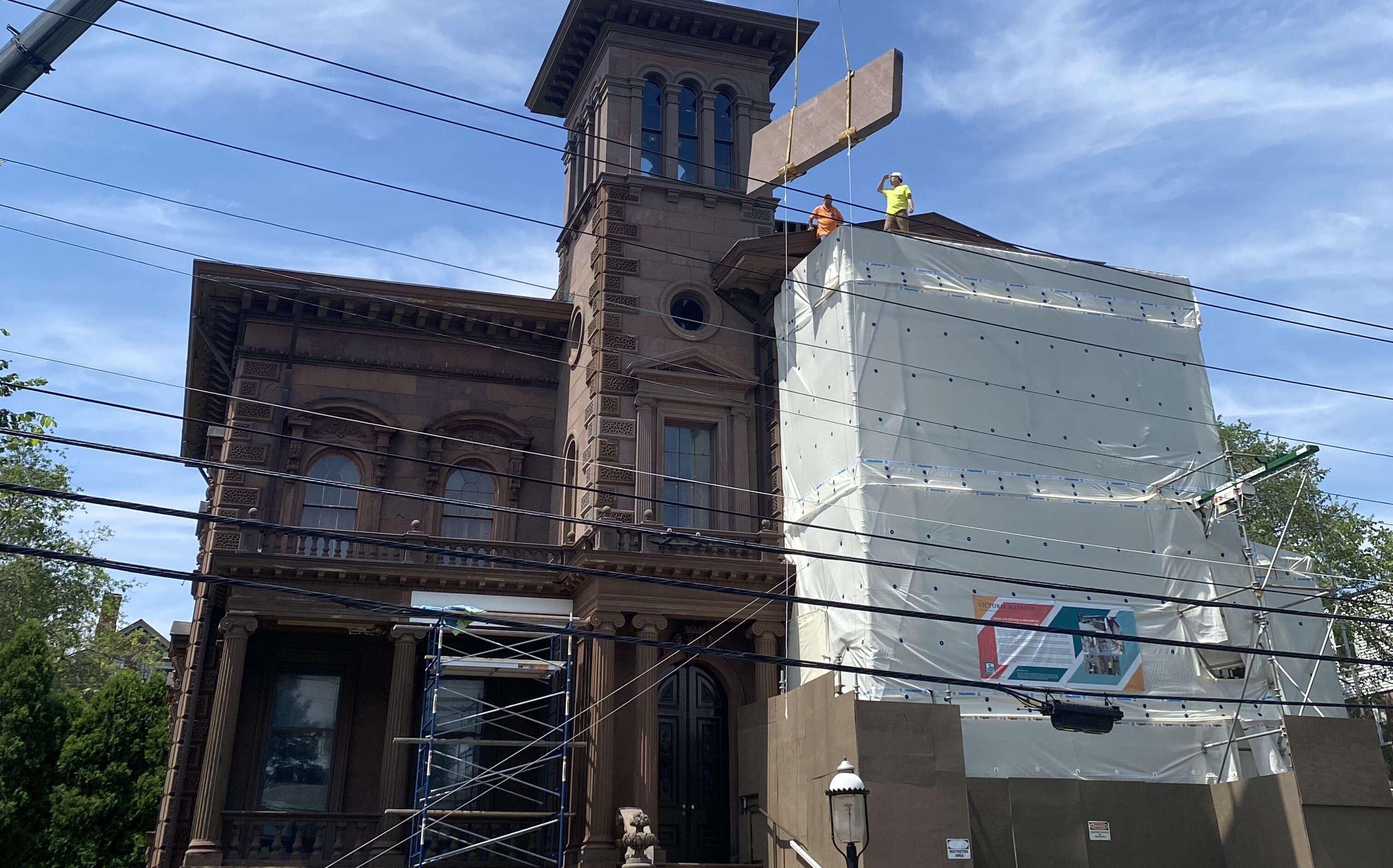 The exterior of an old bulding is surrounded by scaffolds.