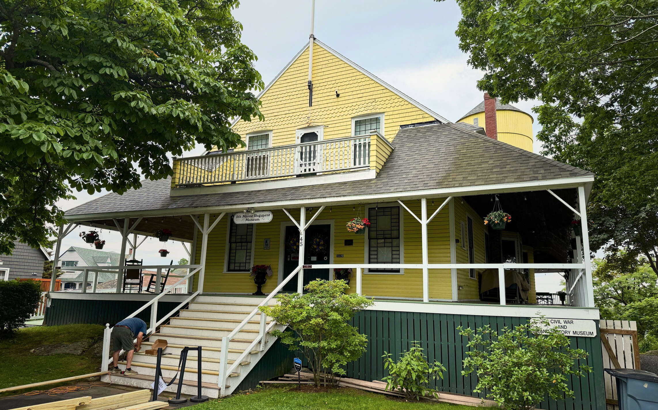 the exterior of a yellow building with a porch.