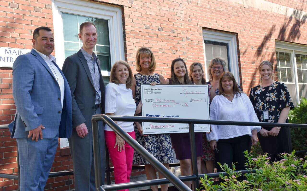 People pose in a line with an oversize check.