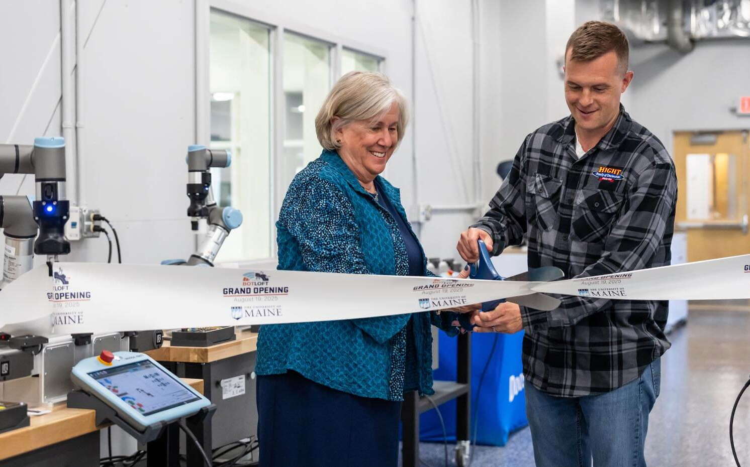 Two people cut a ribbon.