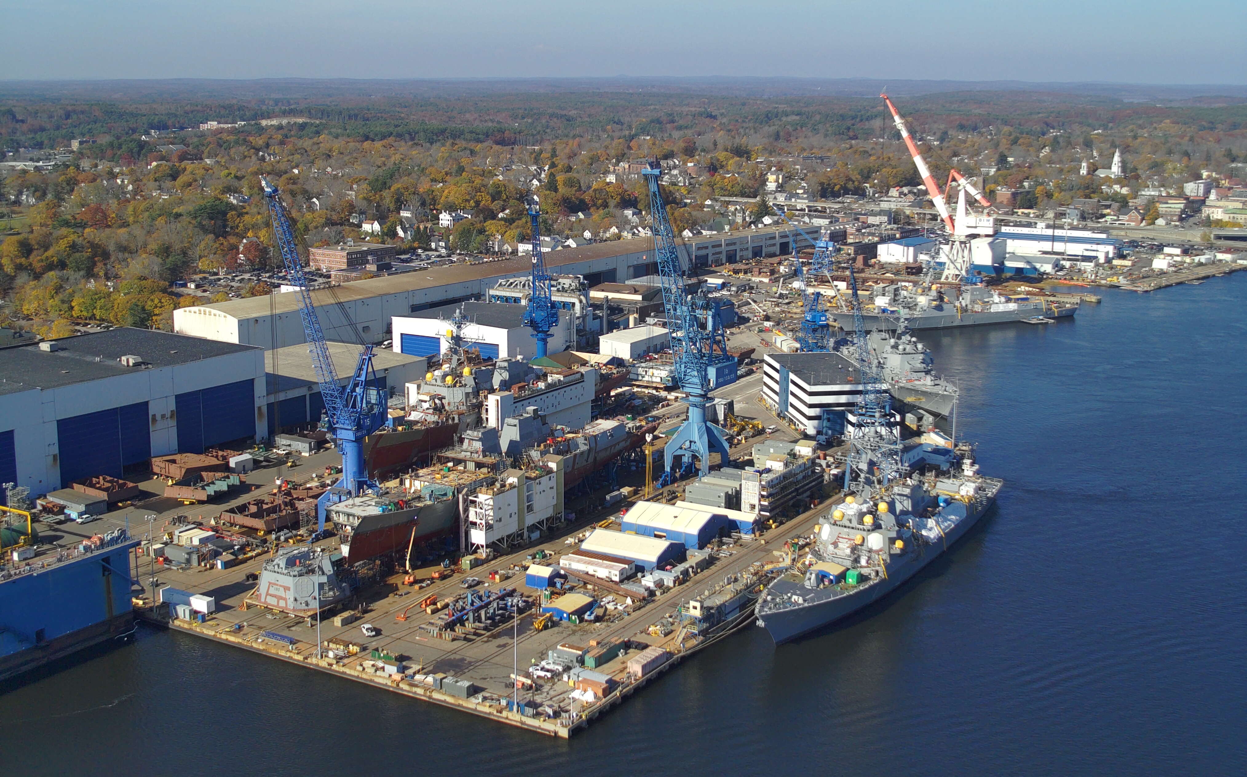 An aerial view of an i ndustrial complex next to water.