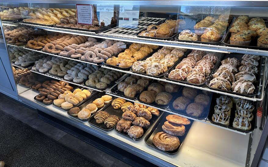 A glass case is filled with baked goods on trays.