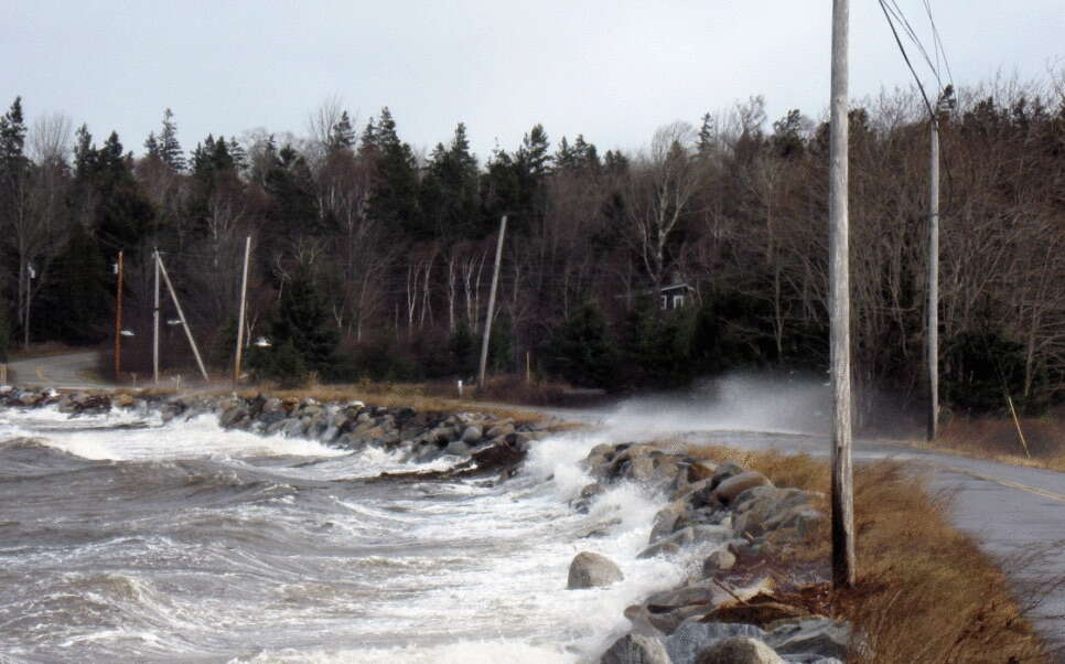 The ocean is washing up onto a road.