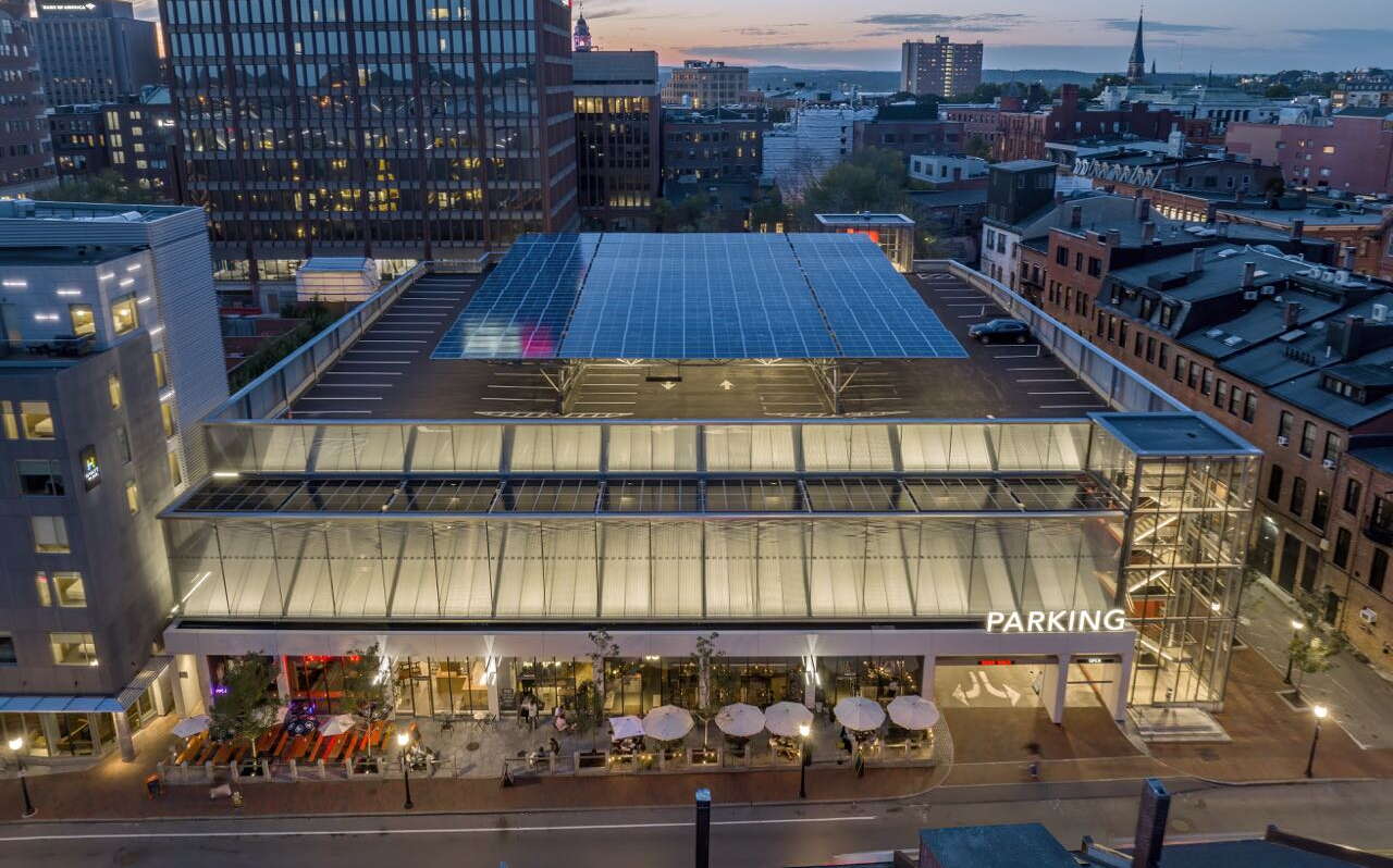 An aerial view shows buildings with lights on.