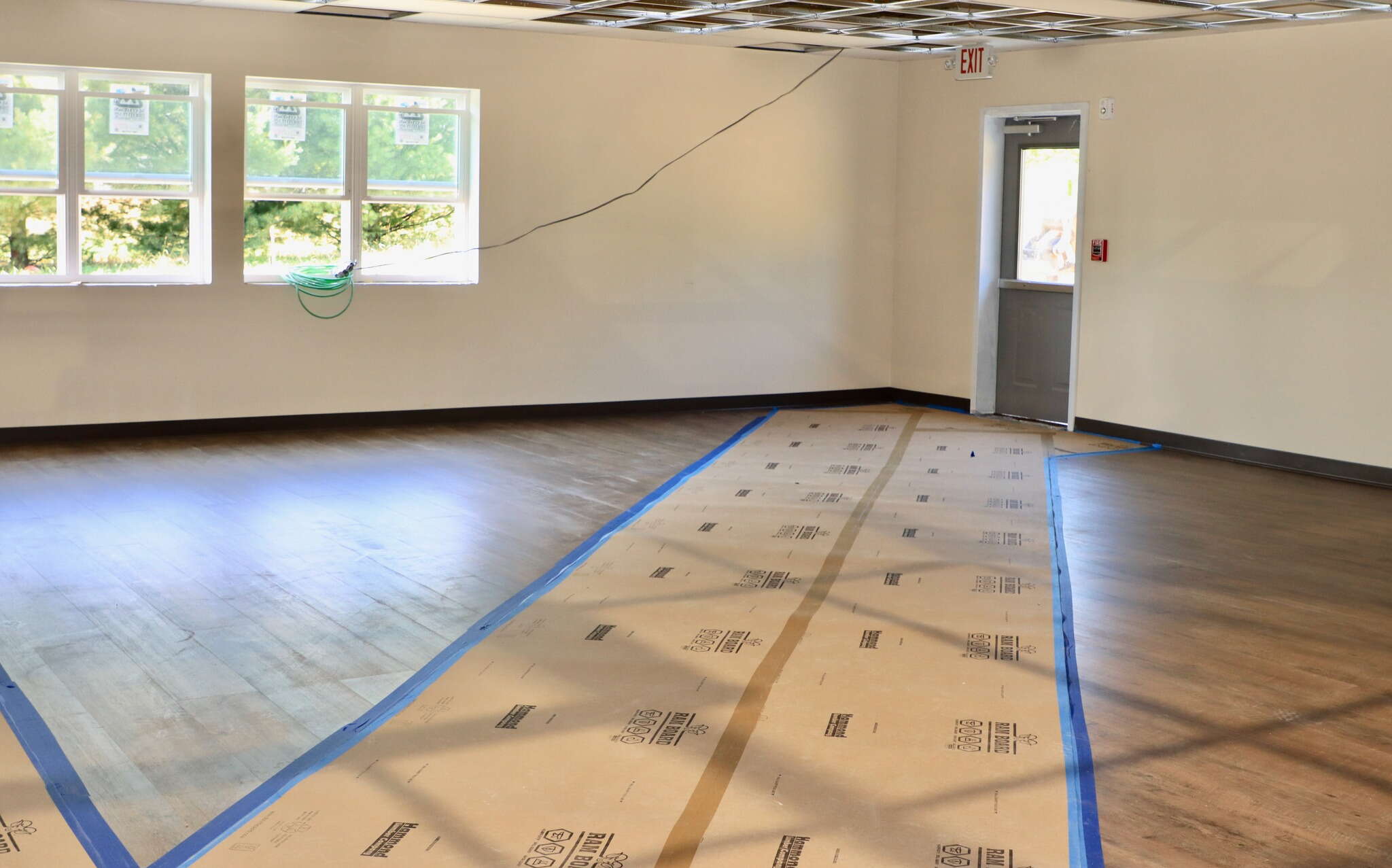 An empty room with a floor that has cardboard taped to it.