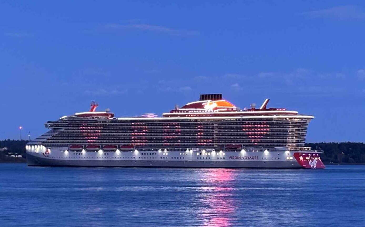 A ship is lit up at dusk.
