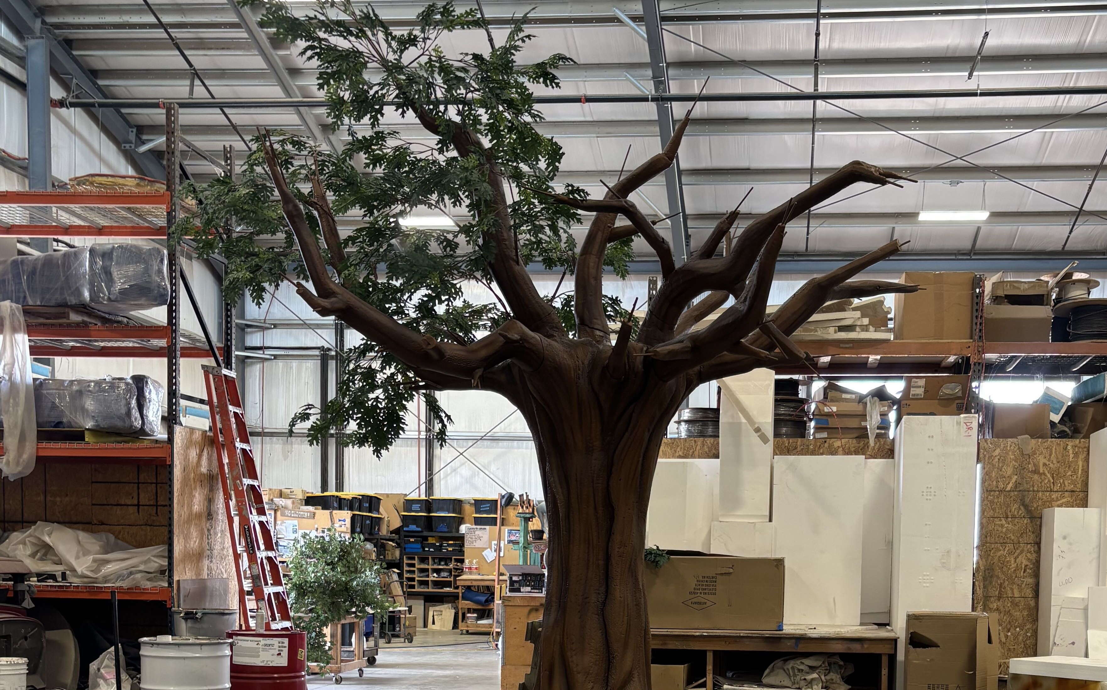 A tree sculpture is inside a big room.