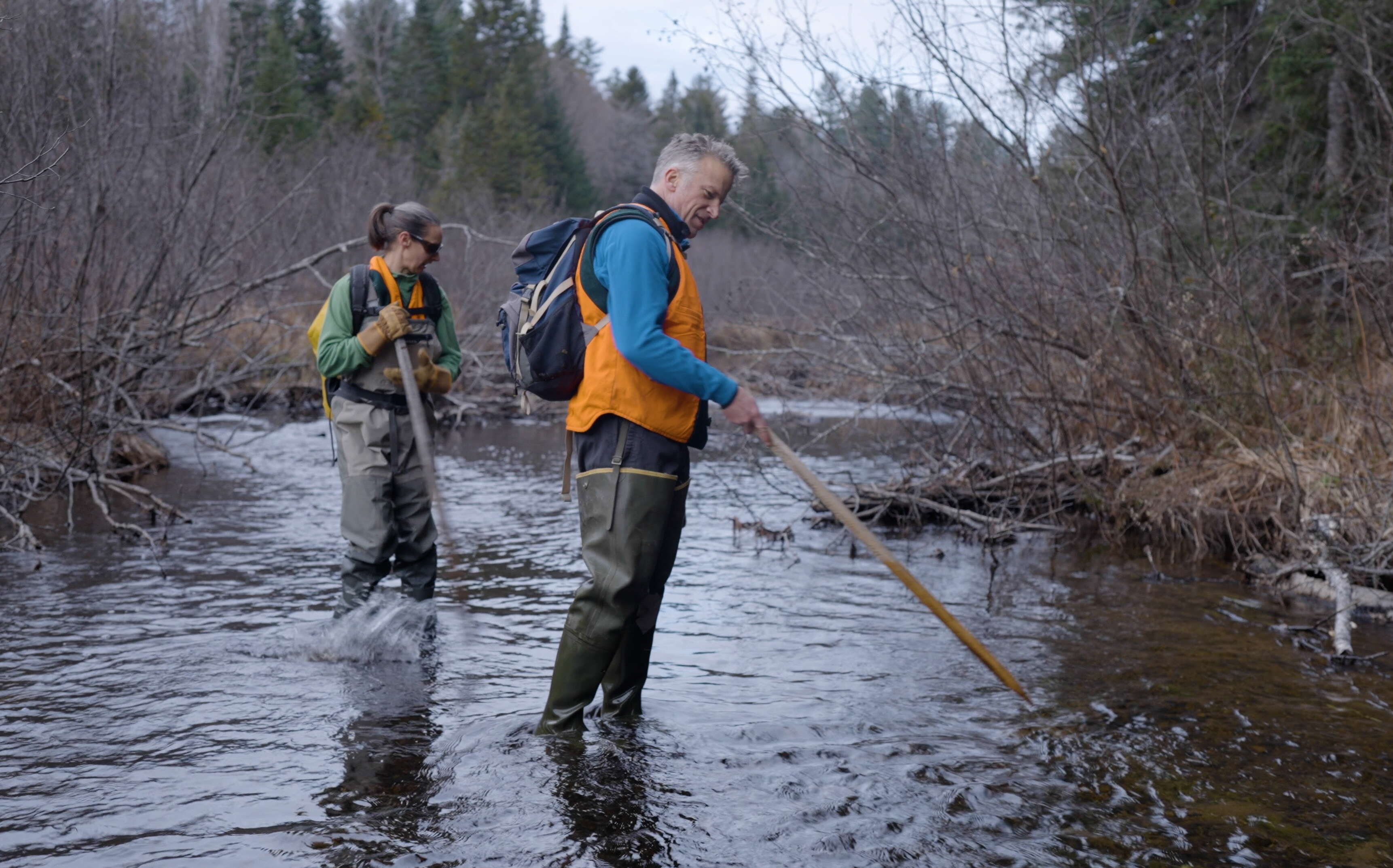 Two people stand in the water.