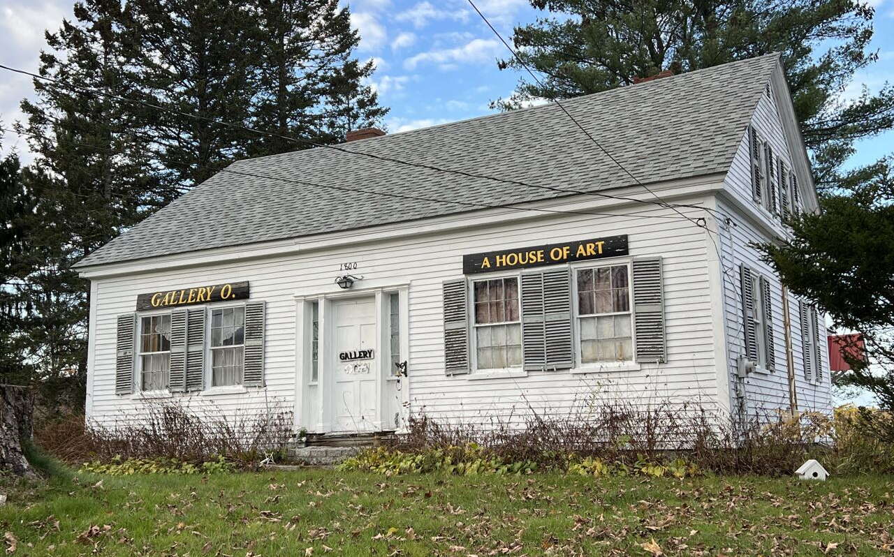 A building hs white siding and a lawn.