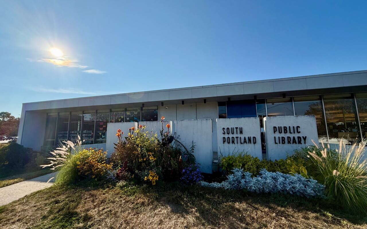 A single-story building with bushes out front.