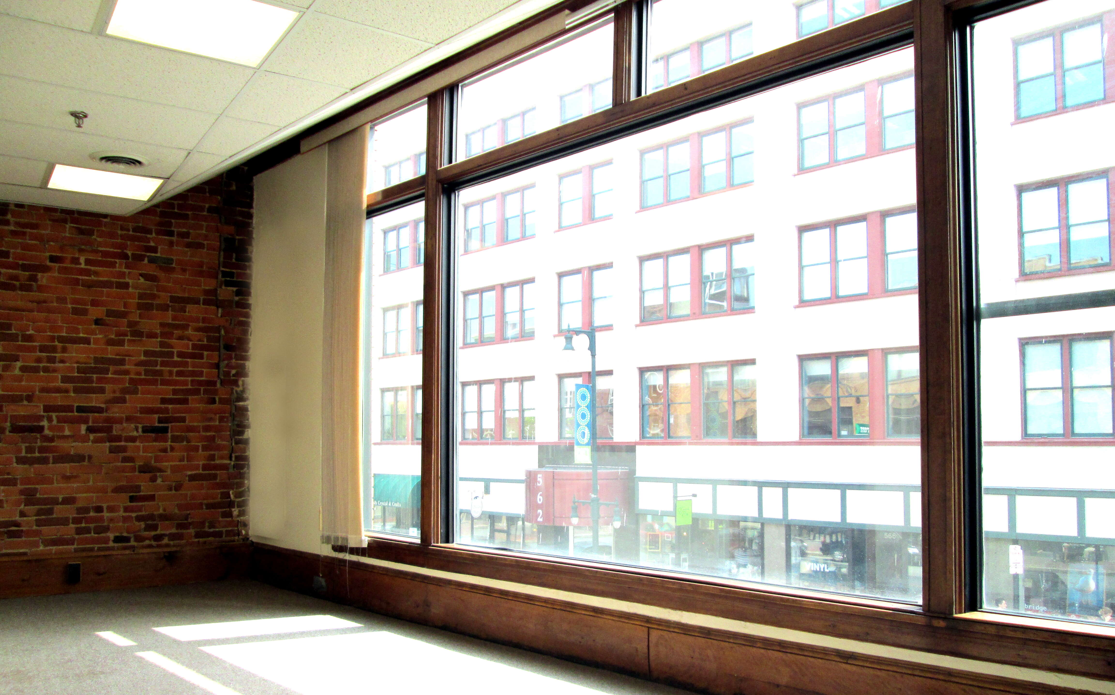 An empty room has large windows.