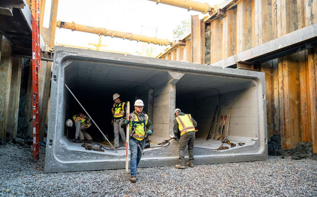 People are wroking around a large cement structure.