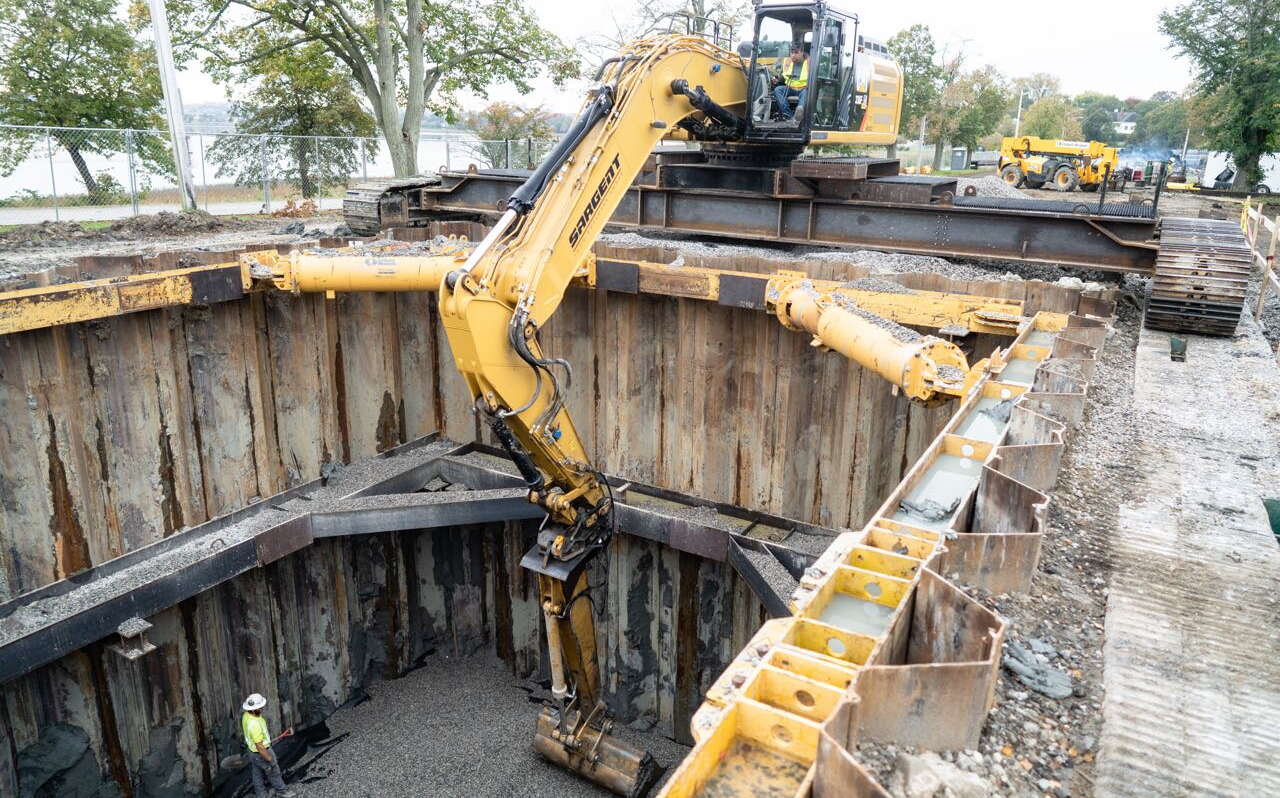 An excavator is above a hole.