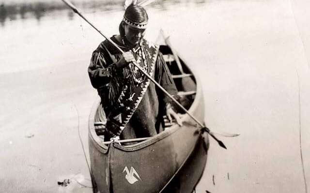 A person is in a canoe with a spear.