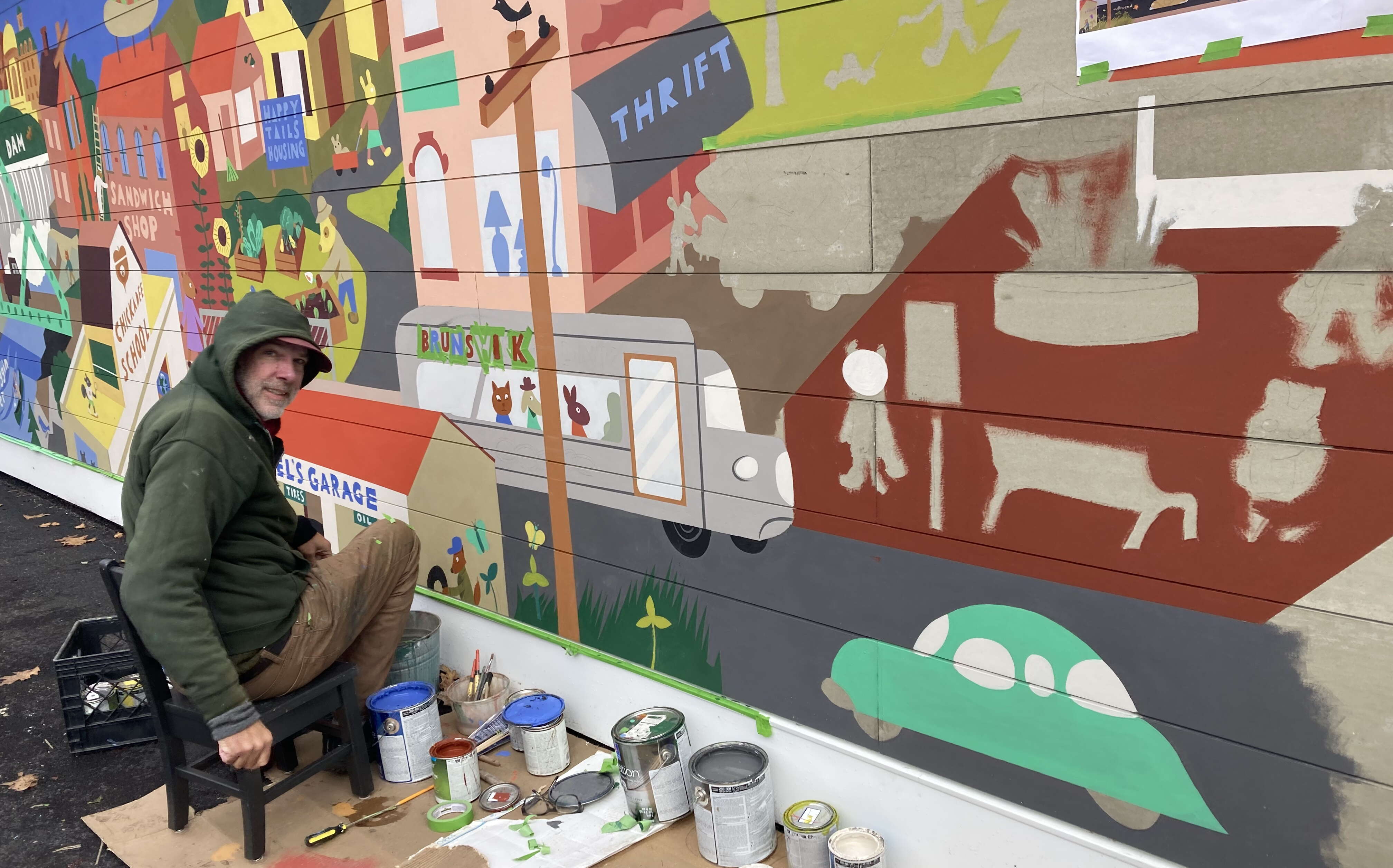 man painting a mural on a building 