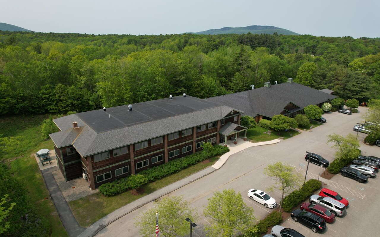 An aerial view of a long building and parking lot.