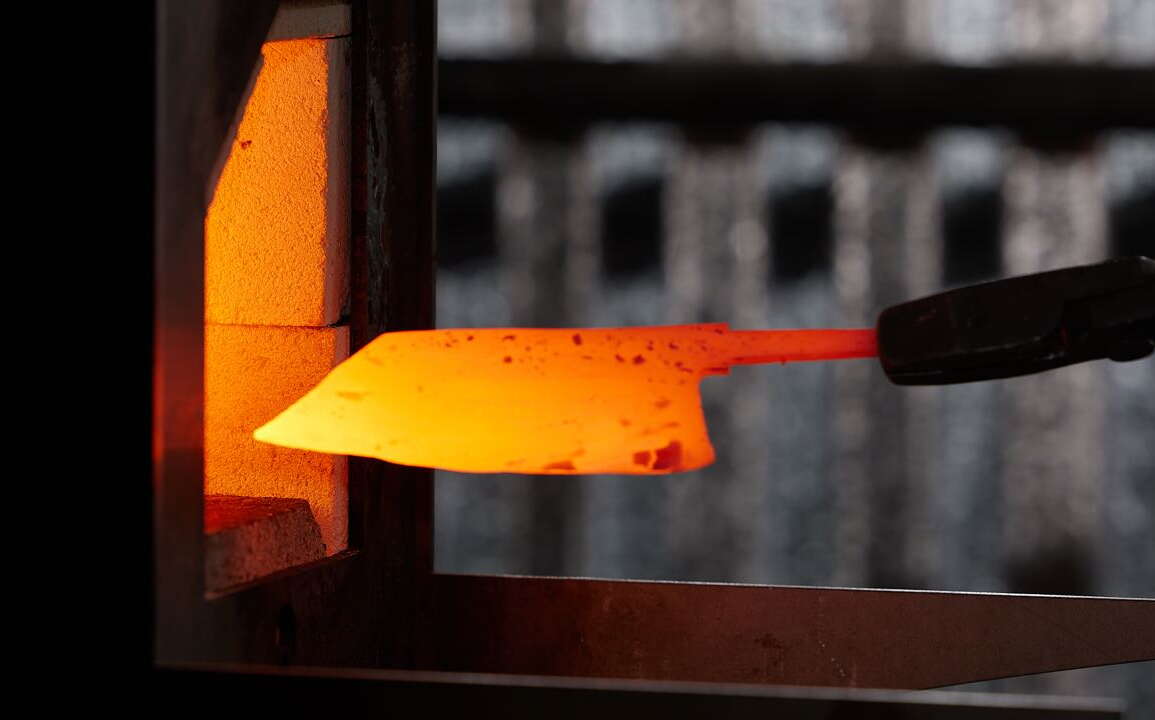 A piece of metal is shaped like a knife blade and heated.