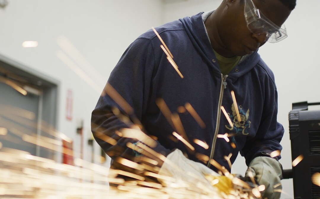 A person works with a tool that causes sparks.