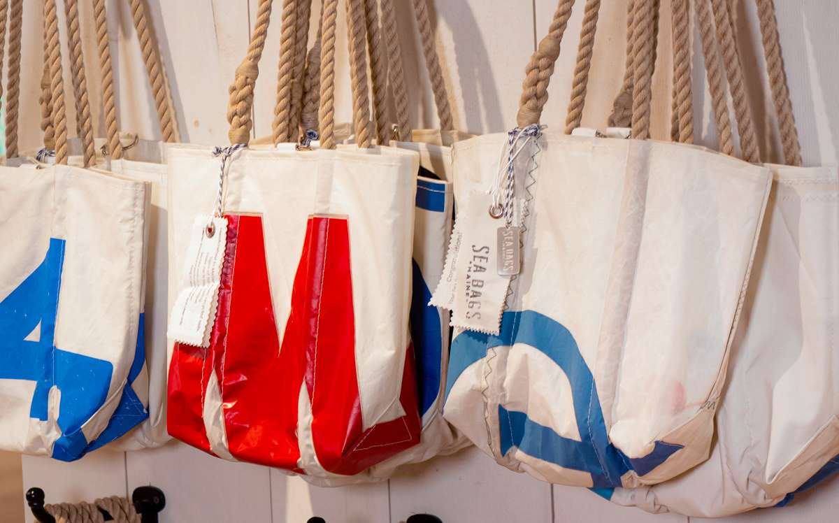 Sea Bags totes displayed in a store hanging on hooks