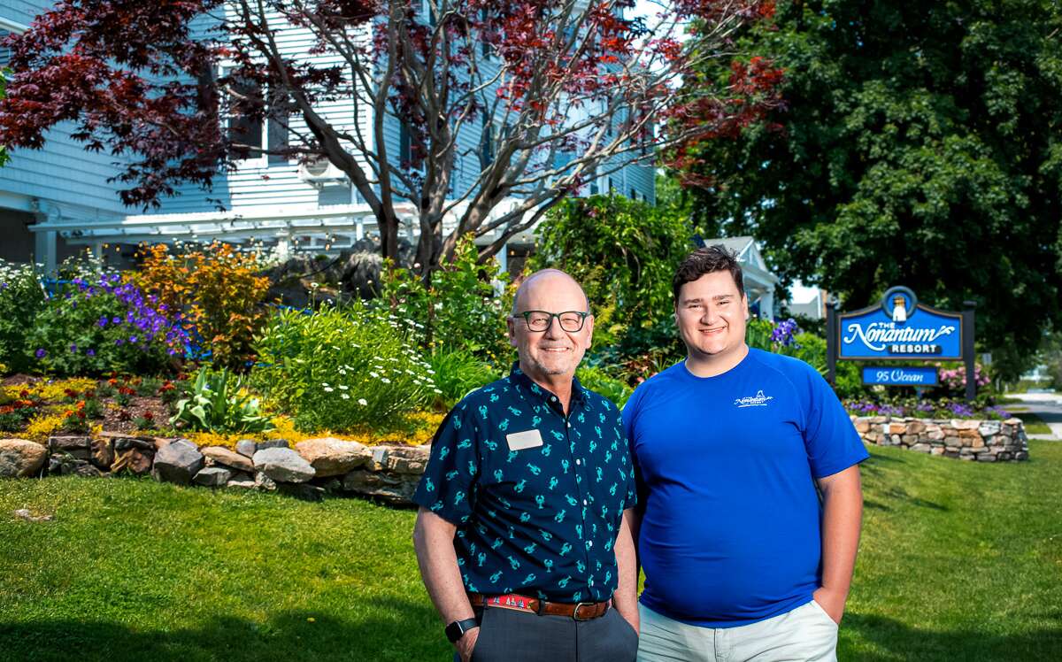 Two men standing in front of hotel.