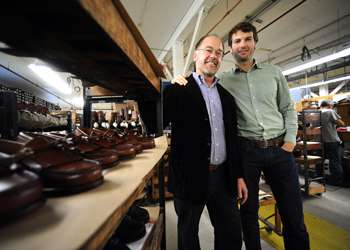 two men standing near racks of shoes