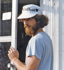 bearded person opening door