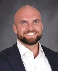 person in white shirt and black blazer smiling