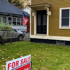 mustard colored house and sign and car