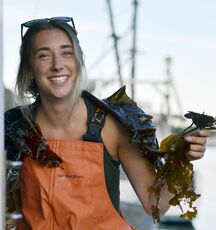 person in overalls with seaweed smiling