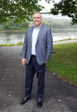 person in sports coat on paved path