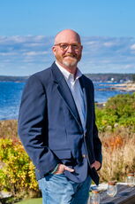 person in blazer standing near shore