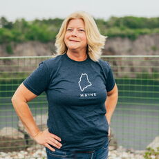 Lynda Adams in a clue shirt with blonde hair.