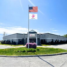 An exterior view of a building with a flag out front.