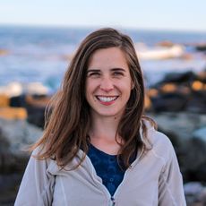 Jenny Kordick standing in front of water and rocks.