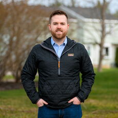 Ryan Fecteau standing outside with a duplex house in the background, in Biddeford