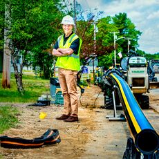 Kurt Adams wearing a hard hat by gas equipment on a job site 