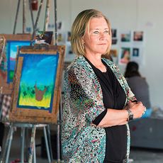 Laura Freid standing among paintings on easels