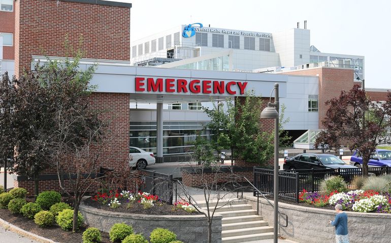 A hospital complex with a sign that says emerency at the front