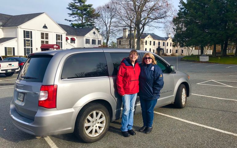 Two women with new minivan to transport people to medical appointments and social outings.