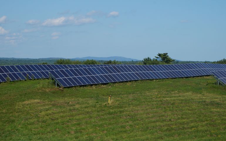 image of solar panels and a grassy field 
