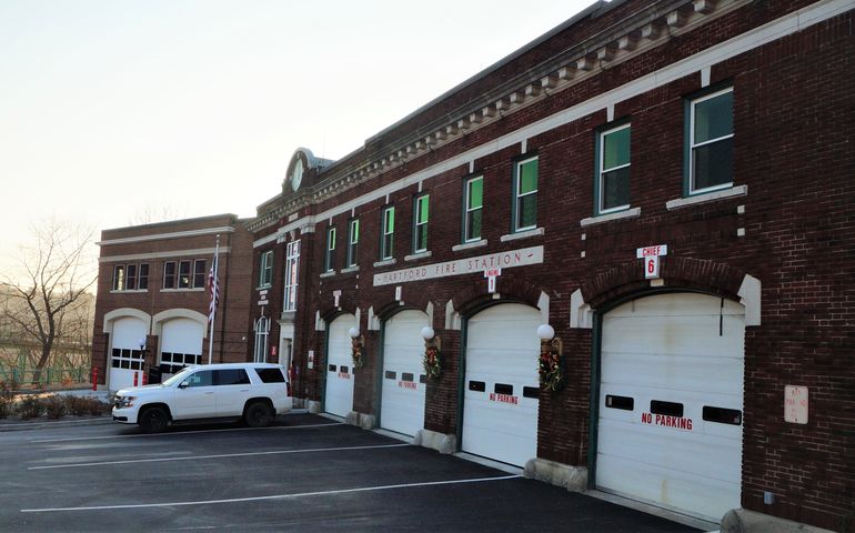 A brick Victorian-era fire station with several bays and a modern brick addition on the far end.