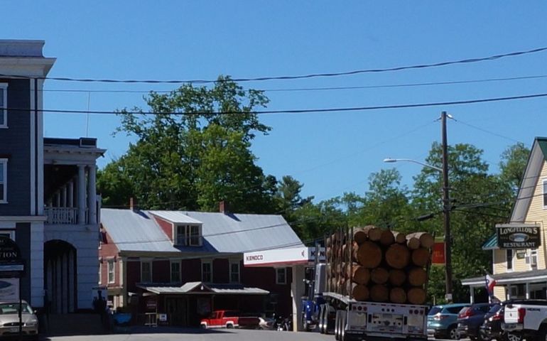 A small town with a logging truck on Main Street