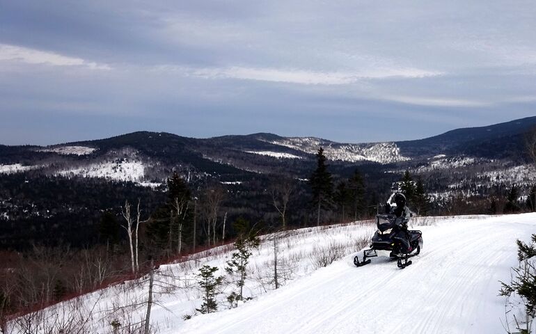 Snowmobiler on a snowy trail in winter 